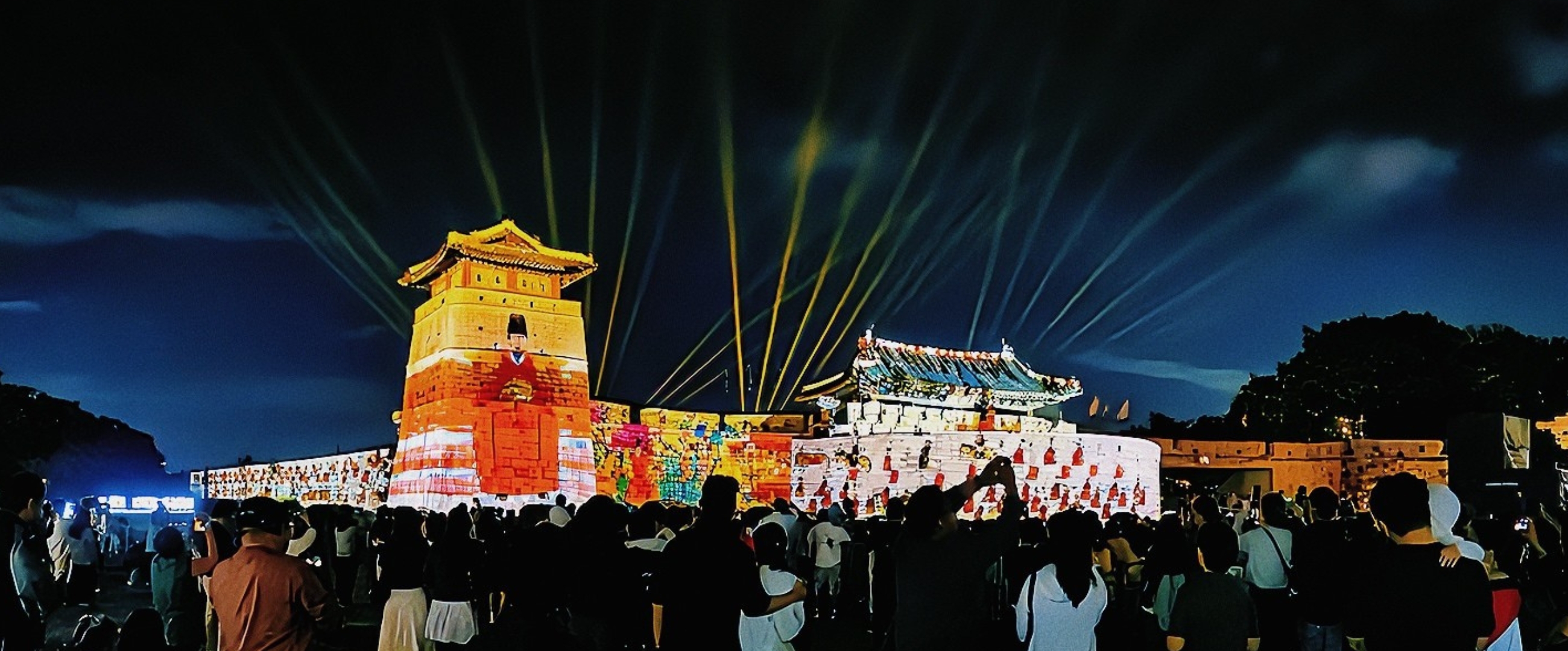 수원 화성 성곽을 스크린 삼아 펼쳐지는 화려한 미디어 아트 쇼. 다채로운 색의 조명과 패턴이 성벽을 가득 채우고 있다.