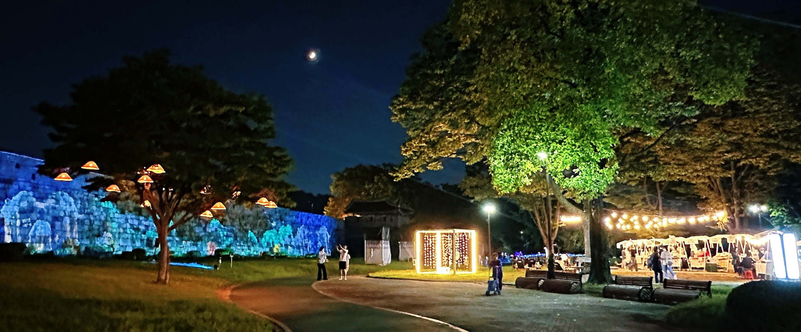 수원 화성 성곽을 스크린 삼아 펼쳐지는 화려한 미디어 아트 쇼. 다채로운 색의 조명과 패턴이 성벽을 가득 채우고 있다.